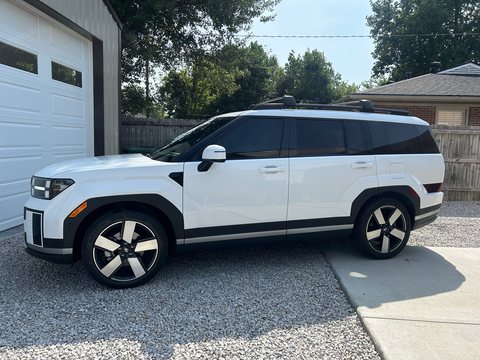 White three-row SUV with tinted windows