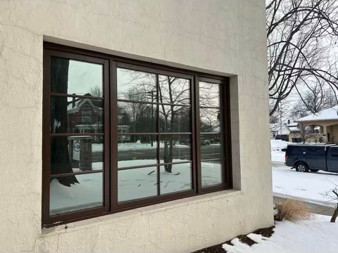 Commercial building window with solar film, winter street reflection