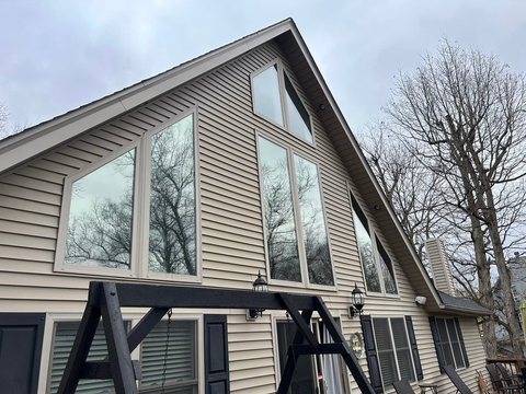 Full gable of a chalet-style home with tinted window wall
