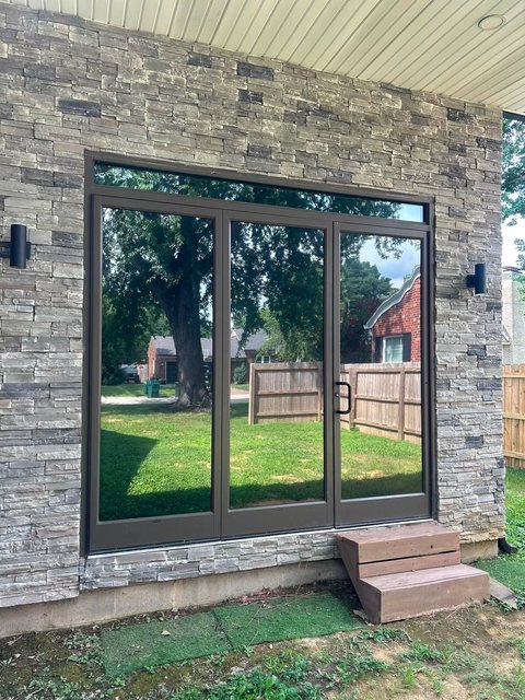 Stone-faced patio entry with tinted sliding glass doors